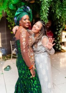 Two ladies smiling to the camera in an event